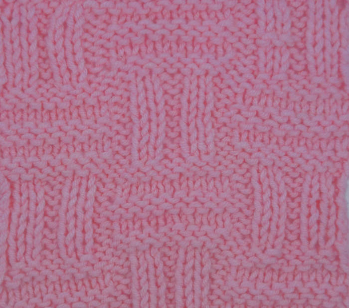 A swatch of the double basket stitch worked in pink yarn.