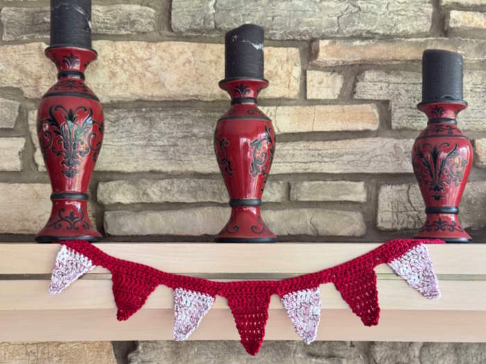 A small bunting made with doucble crochet in red and varigated red