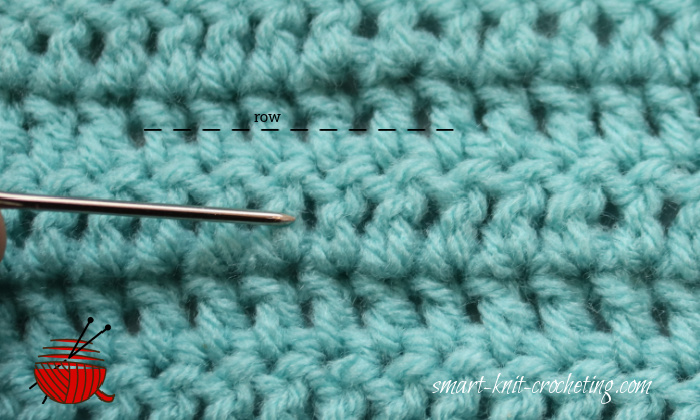 a row of double crochet stitches is pointed out with the needle and dotted line.