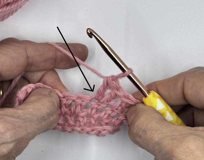 A double crochet increase illustrated in a small pink swatch