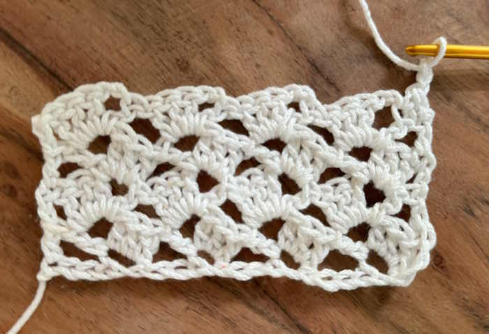 A swatch of drunken granny square worked in cotton and containing multiple rows