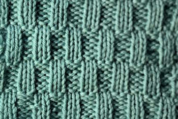Thumbnail image of the elongaged rib stitch knitted in a moss green wool yarn