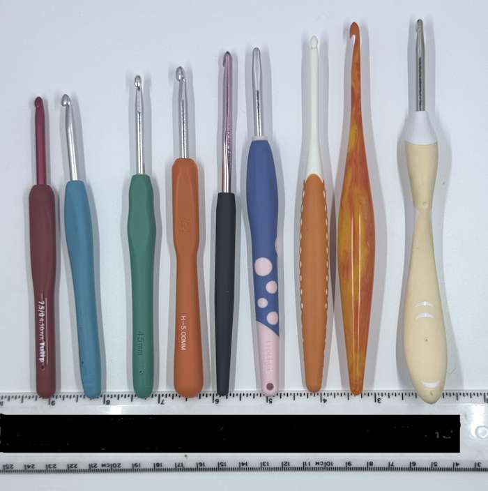 The nine ergonomic crochet hooks tested are lined up by size from shortest to longest The nine ergonomic crochet hooks tested are lined up by size from shortest to longest