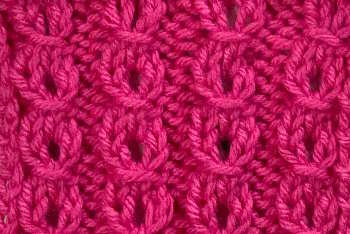 A swatch of the Eyelet Mock Rib Stitch is a thumbnail size and worked in a bright pink