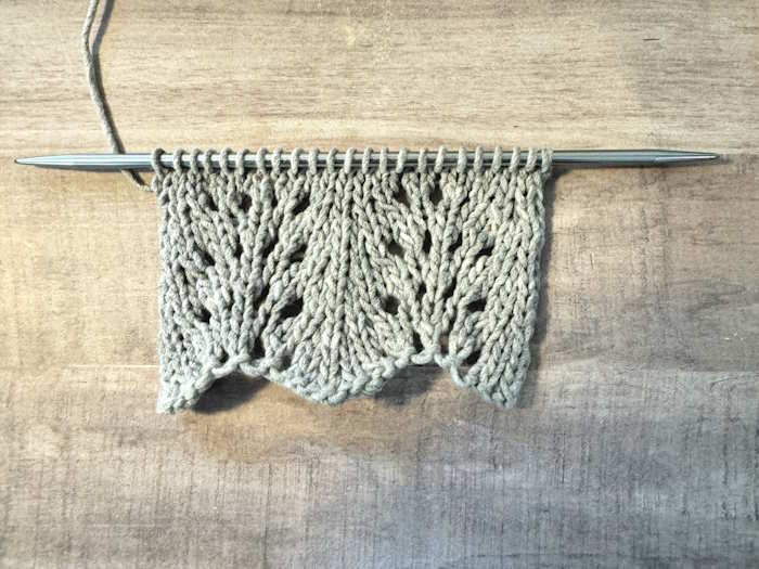 A swatch of the feather and fan knit pattern worked in gray cotton yarn