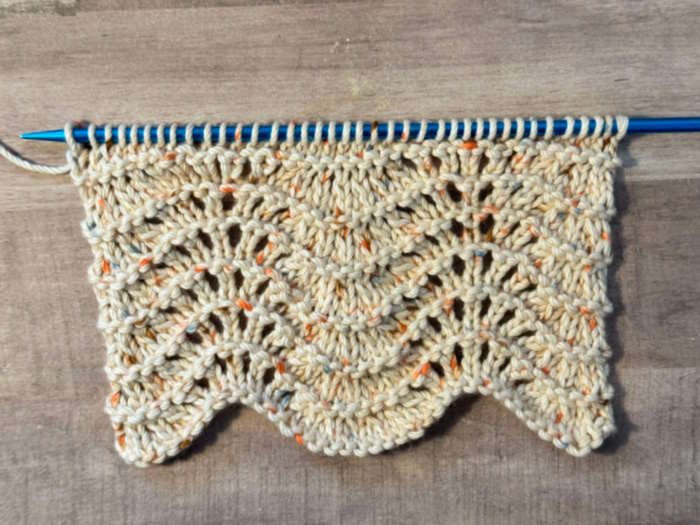 A swatch of feathers and fan knit stitch pattern worked in cotton yarn