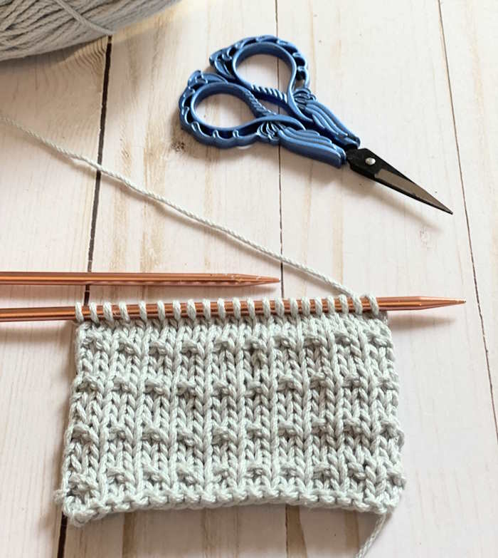 Fleck knit stitch pattern worked in an off white cotton yarn.