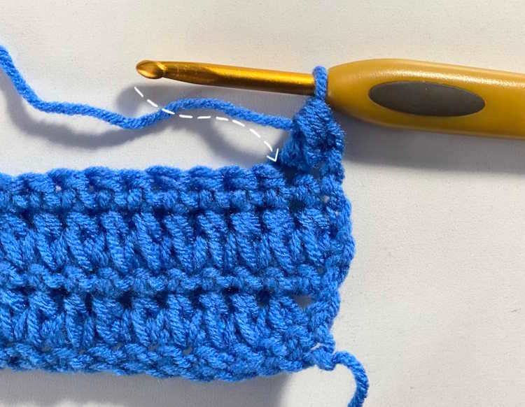 Step by step tutorial for making the forked half double crochet stitch.  Arrow showing where to insert hook for the second stitch.