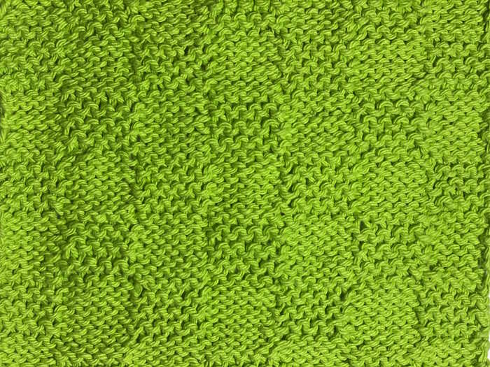 The garter checkerboard stitch worked in green cotton and shown on the reverse side The garter checkerboard stitch worked in green cotton and shown on the reverse side