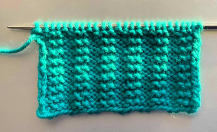 Garter rib stitch pattern worked in green, wrong side showing