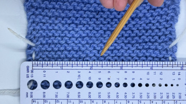 A garter knit stitch swatch with a ruler measuring gauge