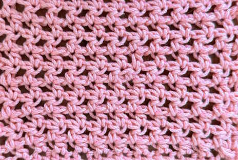 Closeup of a swatch of half double crochet mesh stitch