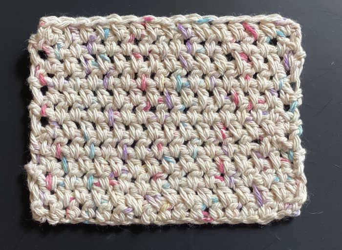 A half double crochet offset stitch is worked into a fabric using 100% cotton yarn.
