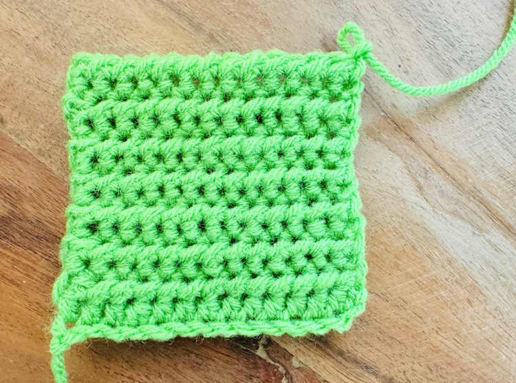 Half double crochet slip stitch worked in green acrylic yarn, showing the wrong side of the fabric
