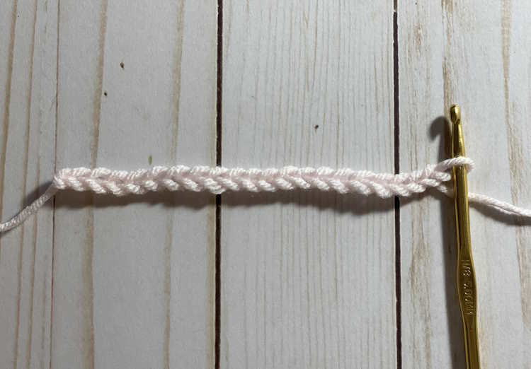 Step by step instructions for making the half double crochet v stitch:  step one