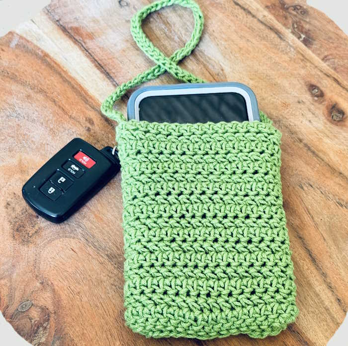 Front side of a Herringbone Half double crochet stitch iPhone case worked in green cotton