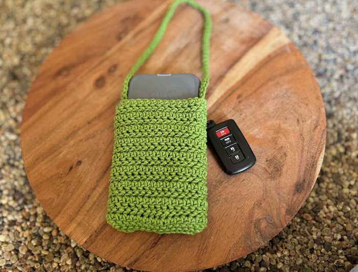 An IPhone case cover worked in the herringbone half double crochet stitch using green cotton yarn