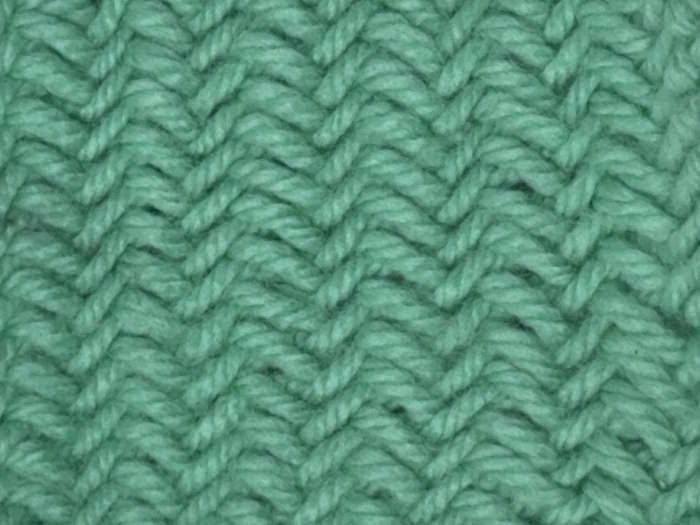The right side of the herringbone knit stitch worked in green