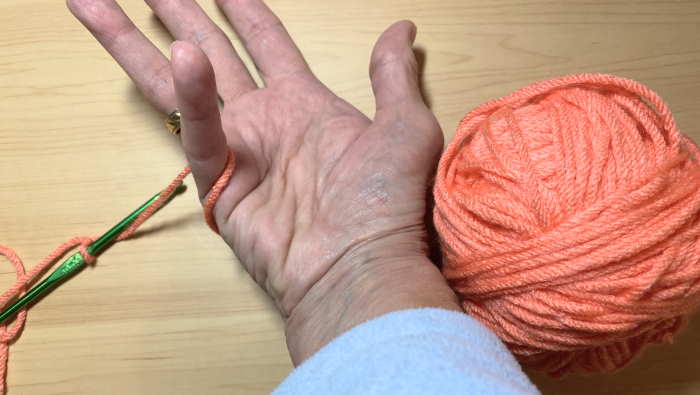 Wrapping yarn around fingers to begin crocheting.