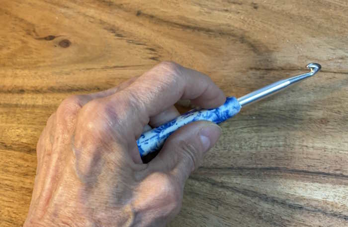 A person with severe arthritis holding a crochet hook using a knife grip