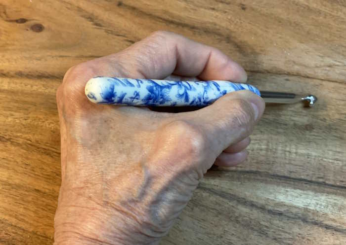 Using a pencil grip to hold a crochet hook by a person with severe arthritis