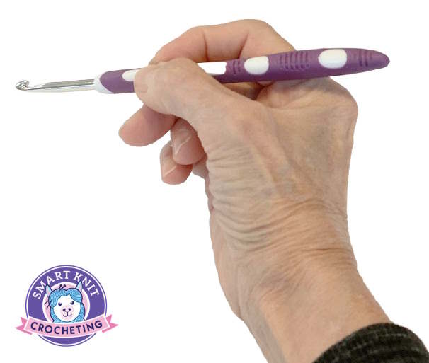 Shown is how to hold a crochet hook the way you might hold a pencil Shown is how to hold a crochet hook the way you might hold a pencil
