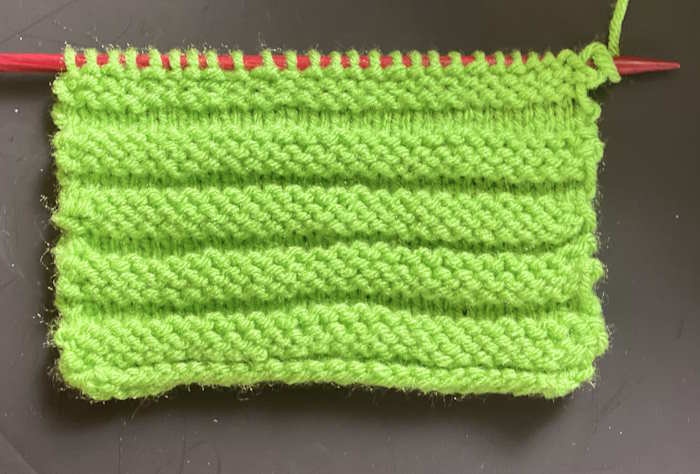 The wrong side showing of the Horizontal Welt Stitch swatch worked in green yarn The wrong side showing of the Horizontal Welt Stitch swatch worked in green yarn