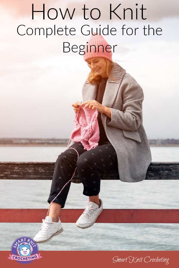 A woman is knitting near the seaside