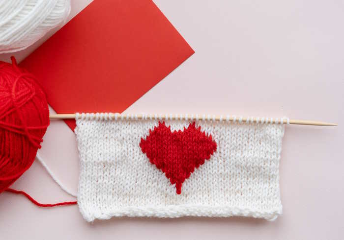An example of intarsia showing a red heart on the background of white.