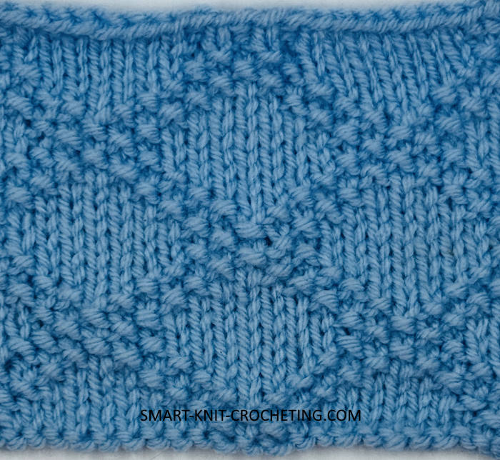 Right side showing of a knitted swatch using the King Charles Brocade stitch pattern in blue Right side showing of a knitted swatch using the King Charles Brocade stitch pattern in blue