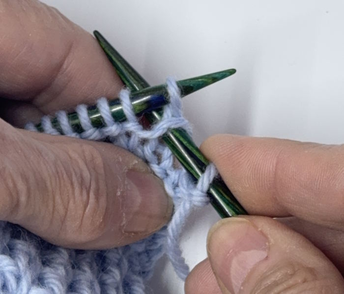 Step two of how to do a knit one below