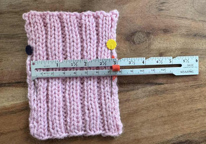A swatch worked in 2 x 2 ribbing with a ruler on top measuring gauge A swatch worked in 2 x 2 ribbing with a ruler on top measuring gauge