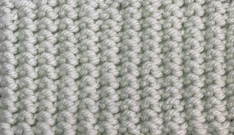 The knit stamen stitch worked in a light green cotton yarn, showing the wrong side.