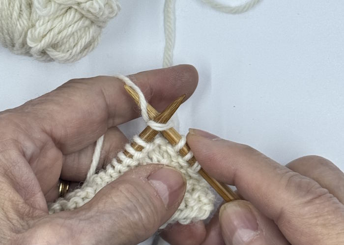Step two of making the knit stitch continental style.