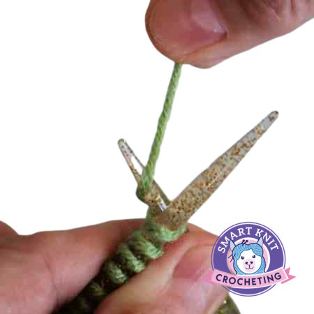 Hands holding knitting needles and showing how to wrap the yarn. Hands holding knitting needles and showing how to wrap the yarn.
