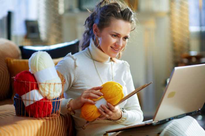 A woman is knitting with yellow yarn