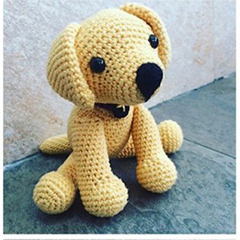 A toy Labrador Retriever is crocheted in a tan colored yarn