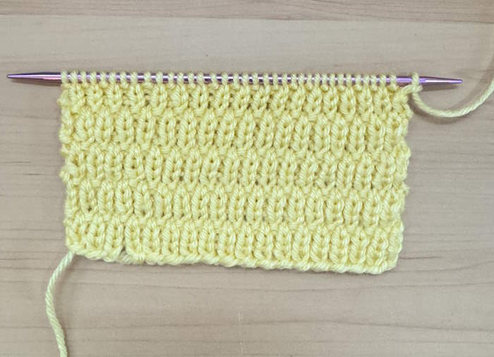 A swatch of the long raindrop knit stitch still on the needles A swatch of the long raindrop knit stitch still on the needles