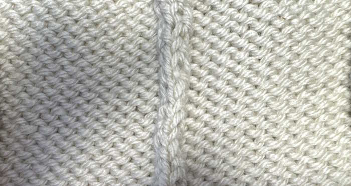 The wrong side showing of the mattress stitch seam on stockinette stitch fabric
