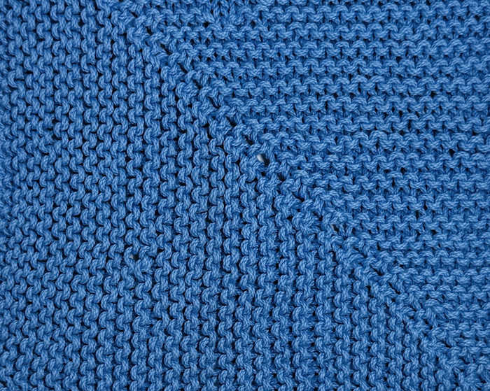 Mitered square washcloth worked in blue cotton yarn