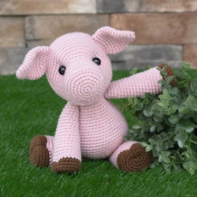 A toy crochet pig worked in pink yarn