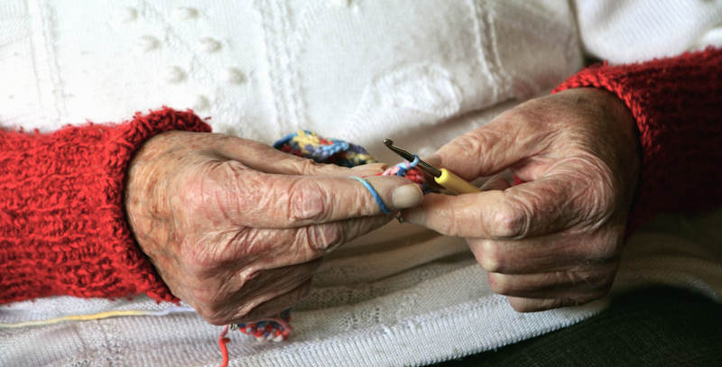 An older person is crocheting