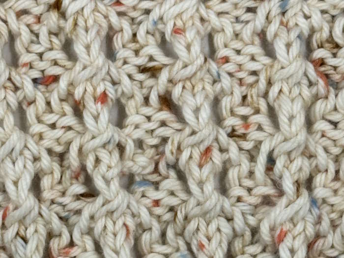 Closeup of the puffed rib stitch worked in a speckled yarn