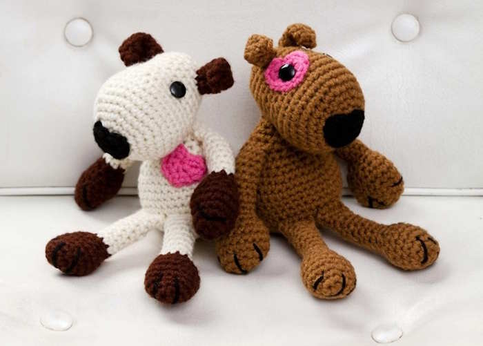 Two toy puppy crocheted in brown and white yarn