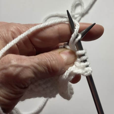 Step-by-step tutorial on making the purl stitch.  This is step 2 Step-by-step tutorial on making the purl stitch.  This is step 2