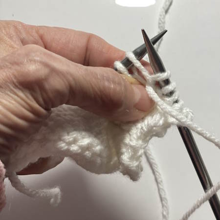 Step-by-step tutorial on making the purl stitch.  This is step 3 Step-by-step tutorial on making the purl stitch.  This is step 3