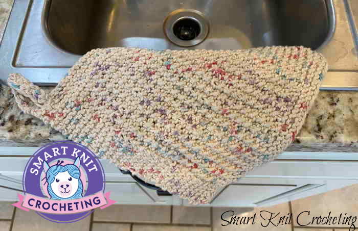 Knitted Rice Stitch dishcloth draped over a kitchen sink
