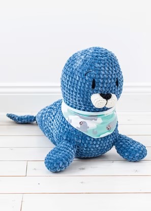 A small toy seal crocheted in blue yarn