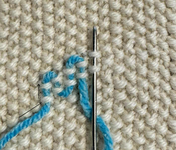 A swatch of seed stitch showing the direction for weaving in ends