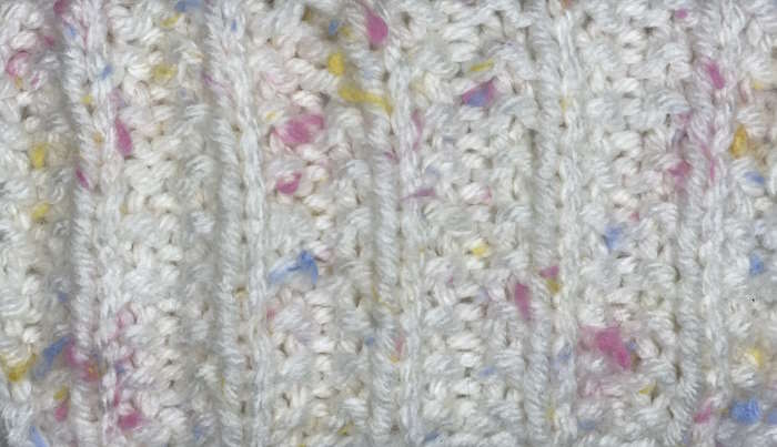Seeded rib knit stitch worked in acrylic worsted weight yarn.